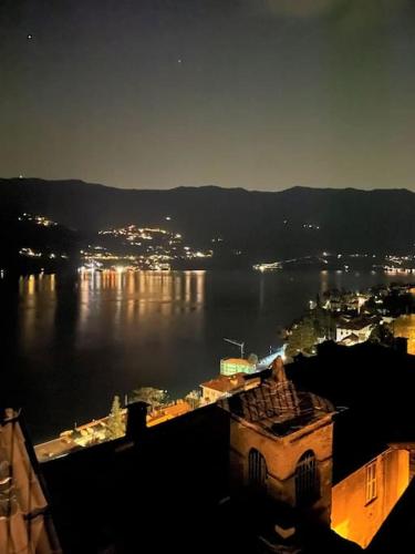 a view of a city and the water at night at Romantic home stone with amazing view lake of Como and Oleandra in Laglio