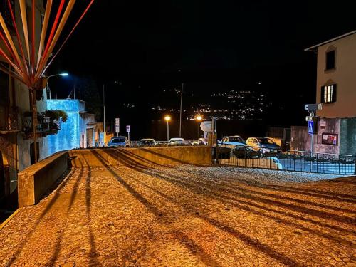 a street at night with cars parked on the road at Romantic home with beautiful view lake of Como and Villa Oleandra in Laglio