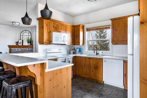 - une cuisine avec des placards en bois et des appareils blancs dans l'établissement Beautiful & Bright 3 Bed Townhome Near Village, à Blue Mountains