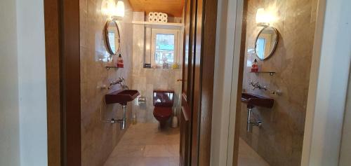 a bathroom with two toilets and two sinks and mirrors at HeidiHoliday geräumige Maisonette-Attica, Sauna & Panoramaterrasse - aufgewertet 2023 in Jenins