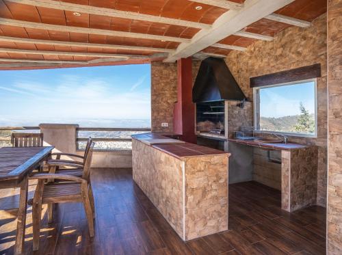a kitchen with a table and a counter with a view at La Casa Roja Torrox 6 huéspedes y piscina privada in Torrox