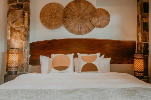 a bedroom with a bed with a wooden headboard and pillows at Sansara Surf Yoga & Resort in Cambutal