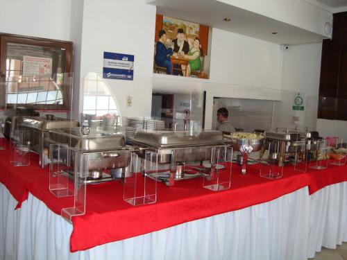 a kitchen with a red table with food on it at Hotel Plaza Versalles in Cali