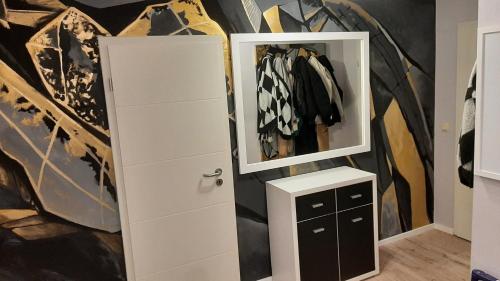 a closet with a mirror and a white cabinet at Suite Stuermer in Nordhausen