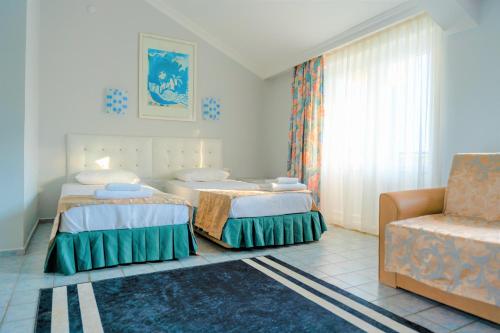 a bedroom with two beds and a chair and a couch at MiraSu Hotel in Agva