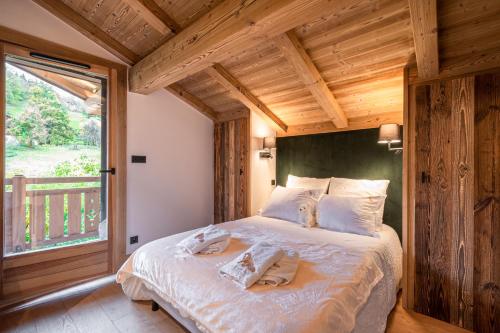 um quarto com uma cama grande num quarto com uma janela em Chalet Isatis em Megève