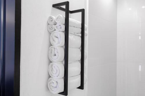 a towel rack with white towels on a wall at DUM Hotel - Si Phum in Chiang Mai