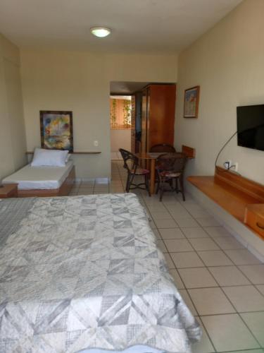 Schlafzimmer mit einem Bett, einem TV und einem Tisch in der Unterkunft Maria Leuça Teixeira Duarte in Natal