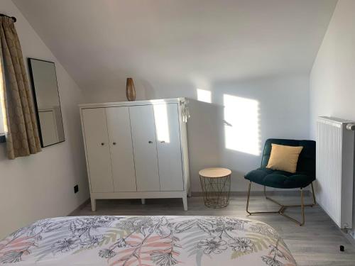 a bedroom with a bed and a chair and a dresser at Gites Douillets for the Family in Houyet