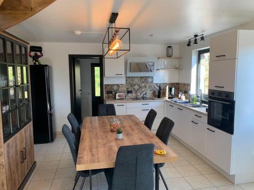 a kitchen with a wooden table and chairs in it at Gites Douillets for the Family in Houyet