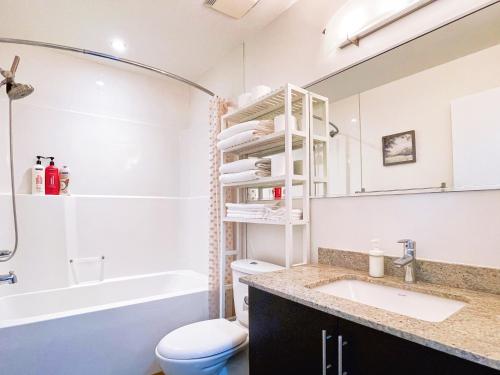 a bathroom with a sink and a toilet and a mirror at 2BR condo in downtown, w/ view+parking in Calgary