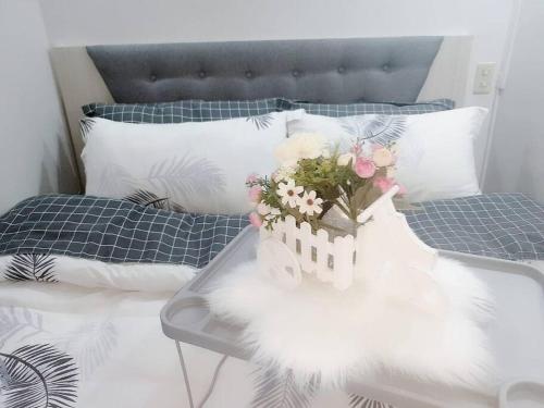 a white bed with a bouquet of flowers on it at The Tranquil Haven in Manila