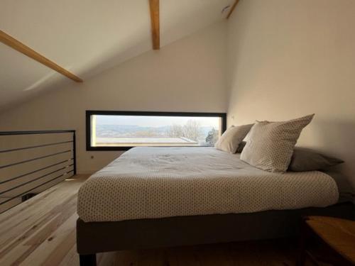a bedroom with a large bed with a window at Gite chez Polo in Les Mételles