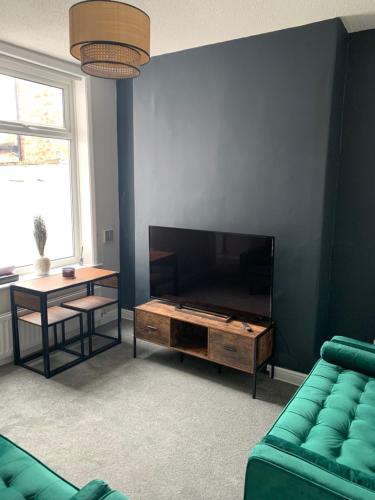 a living room with a couch and a flat screen tv at Ayresome House in Middlesbrough