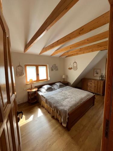 a bedroom with a large bed in a attic at Domek letniskowy Opowieści z Narie Kretowiny in Kretowiny