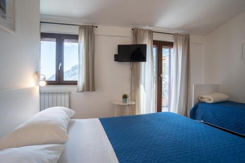 Un dormitorio con una cama azul y blanca y una ventana en Casa dell'Escursionista, en Cerchiara di Calabria
