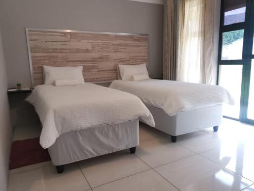 dos camas sentadas una al lado de la otra en un dormitorio en @Home BnB en Maseru
