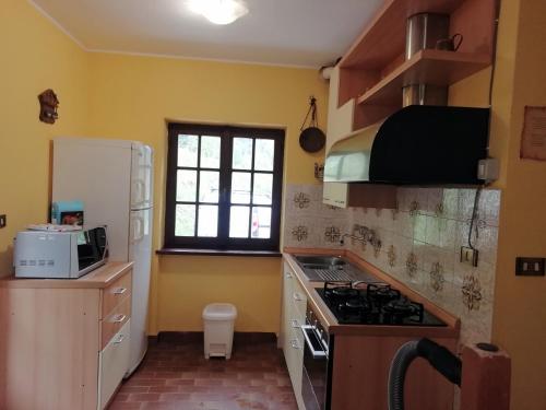 a kitchen with a stove and a white refrigerator at Chalet Niki BELLAGIO in Bellagio