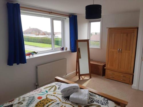 een slaapkamer met een bed, een raam en een spiegel bij Spacious, self-contained, 1 bedroomed annex in Bempton