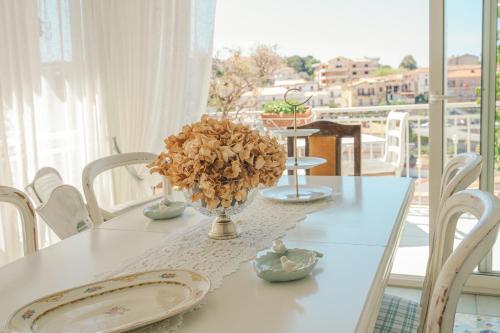 een witte tafel met een vaas met bloemen erop bij La casa nel borgo in San Nicola Arcella