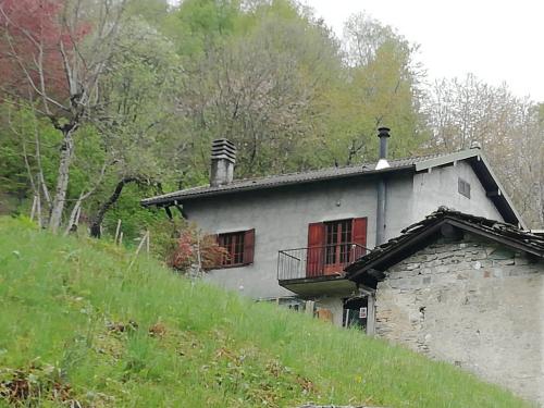 ein altes Haus mit Balkon auf einem Hügel in der Unterkunft Chalet Niki BELLAGIO in Bellagio