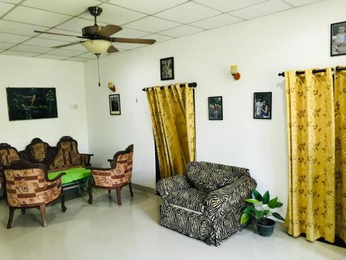 a living room with chairs and a ceiling fan at Menara Villa in Kamburugamuwa