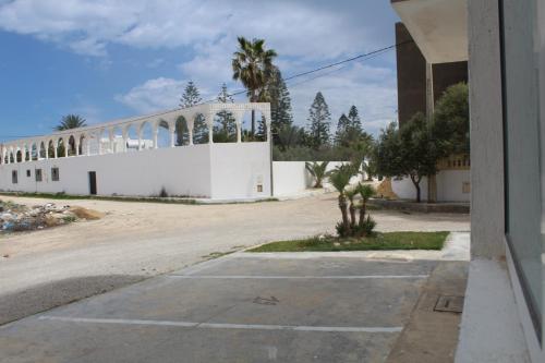 un edificio blanco con palmeras a un lado en Relaxing Vacation Stay in Mahdia en Rejiche