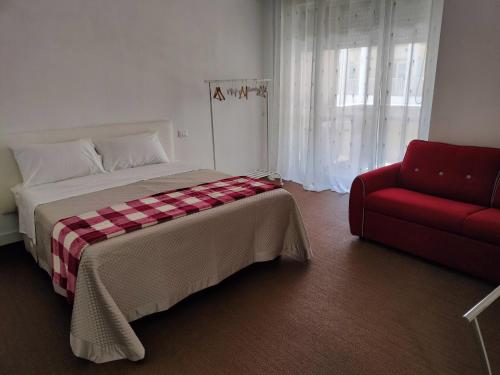 um quarto com uma cama e um sofá vermelho em Matera Like Home - rooms - Via del Corso em Matera