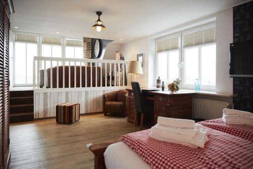 Cette chambre comprend deux lits, un bureau et une chaise. dans l'établissement Bernstein-Hotel Bootshaus, à Büsum