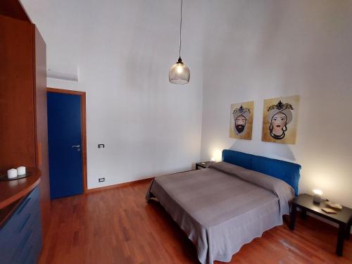 Terrazza San Camillo في كاتانيا: غرفة نوم بسرير وصورتين على الحائط