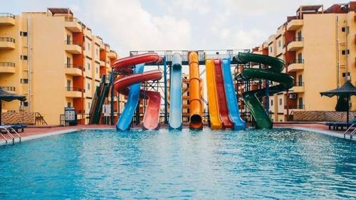 um escorrega aquático no meio de uma piscina em شاليه فندقي للعائلات ريتال ڤيو حمام السباحه em El Alamein