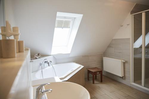 a bathroom with a bath tub and a sink at Bernstein-Hotel Bootshaus in Büsum