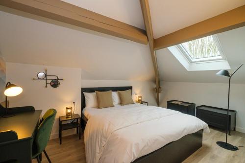 a bedroom with a large bed and a skylight at Villa Forestière Appart Le Cèdre in Quincy-Voisins