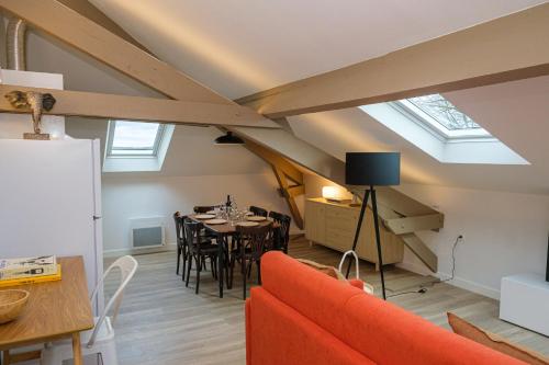 a living room with a dining room table and skylights at Villa Forestière Appart Le Cèdre in Quincy-Voisins