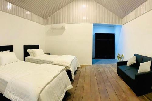 - une chambre avec 2 lits et un canapé dans l'établissement Surge Surf Villas, à Lasikin