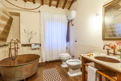 bagno con vasca in rame, servizi igienici e lavandino di CasAnnona a Fermo