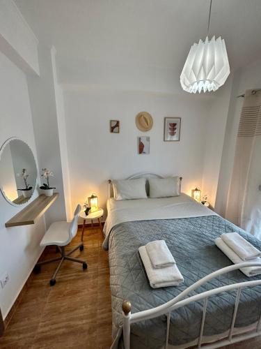 a bedroom with a bed and a desk and a chair at My Bright House in Afitos