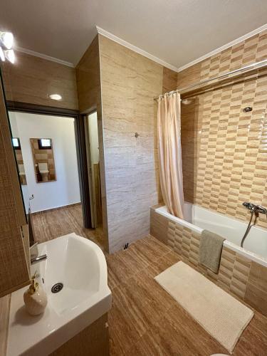 a bathroom with a tub and a sink and a bath tub at My Bright House in Afitos