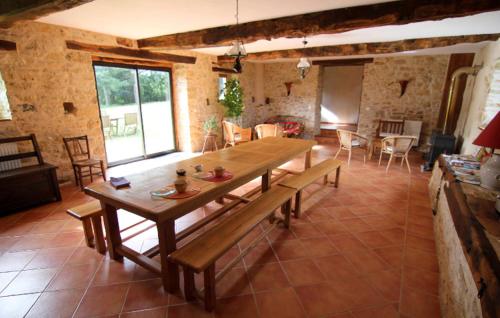Cette grande chambre dispose d'une table et de chaises en bois. dans l'établissement Maison d'hôtes Bélinaire - Au coeur de la nature, à Cazeneuve-Montaut