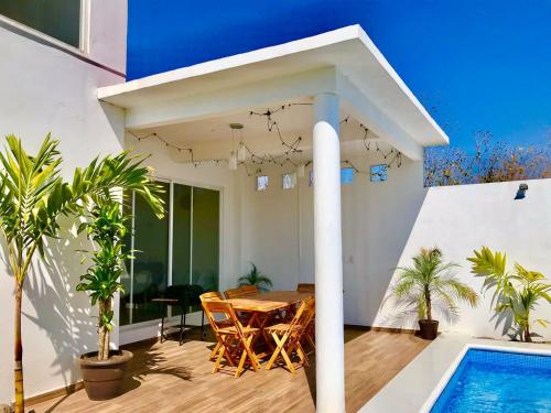 a house with a table and a swimming pool at Casa con alberca climatizada en Cuautla Morelos in Los Limones