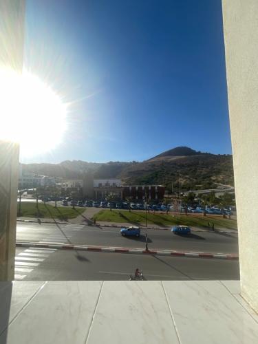 een uitzicht op een parkeerplaats met de zon in de lucht bij Hôtel ALMUNECAR in Al Hoceïma