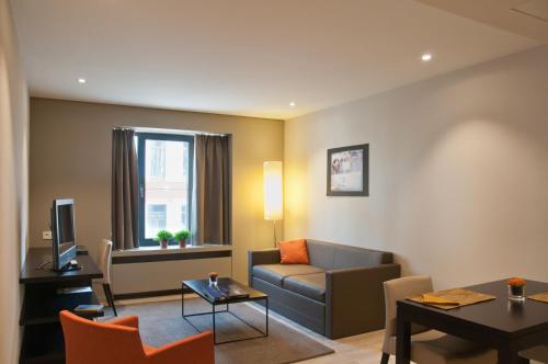 sala de estar con sofá y mesa en Castelnou Aparthotel en Ghent