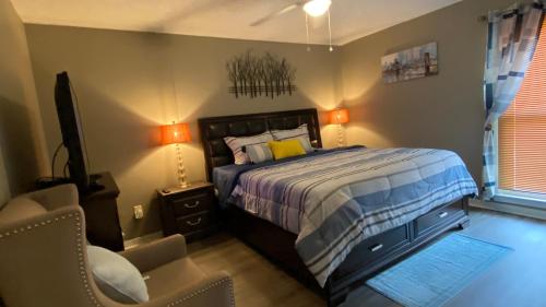 a bedroom with a bed and a chair and a television at Red Door North Jackson-Ridgeland Vacation Home in Jackson