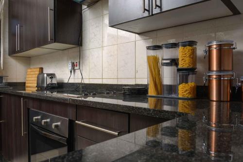 a kitchen with a counter top with pasta on it at acaciaoptimumstay in Gaborone