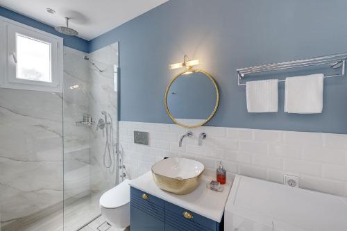 bagno con lavandino, servizi igienici e specchio di Polis Suite a Ermoupoli