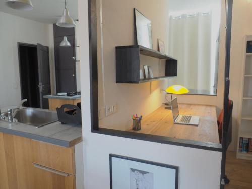 - une cuisine avec un comptoir, un évier et un miroir dans l'établissement Calme et confort en coeur de ville, à Draguignan