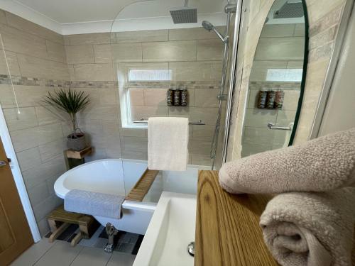 a bathroom with a tub and a toilet and a sink at Rasen Cottage in Lincolnshire