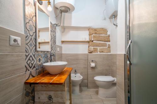 a bathroom with a sink and a toilet and a mirror at Dery Alghero Holiday La Torre in Alghero