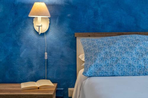 a bedroom with a bed with a lamp and a book on a table at Dery Alghero Holiday La Torre in Alghero