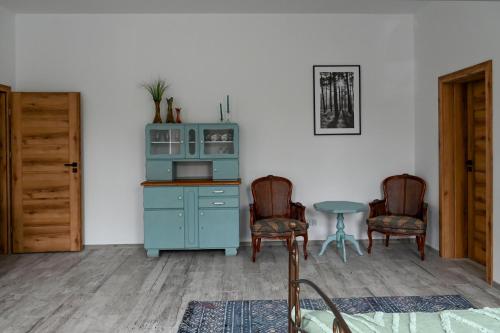 cocina con armario azul y 2 sillas en Apartament Niezapominajka, en Głuchołazy